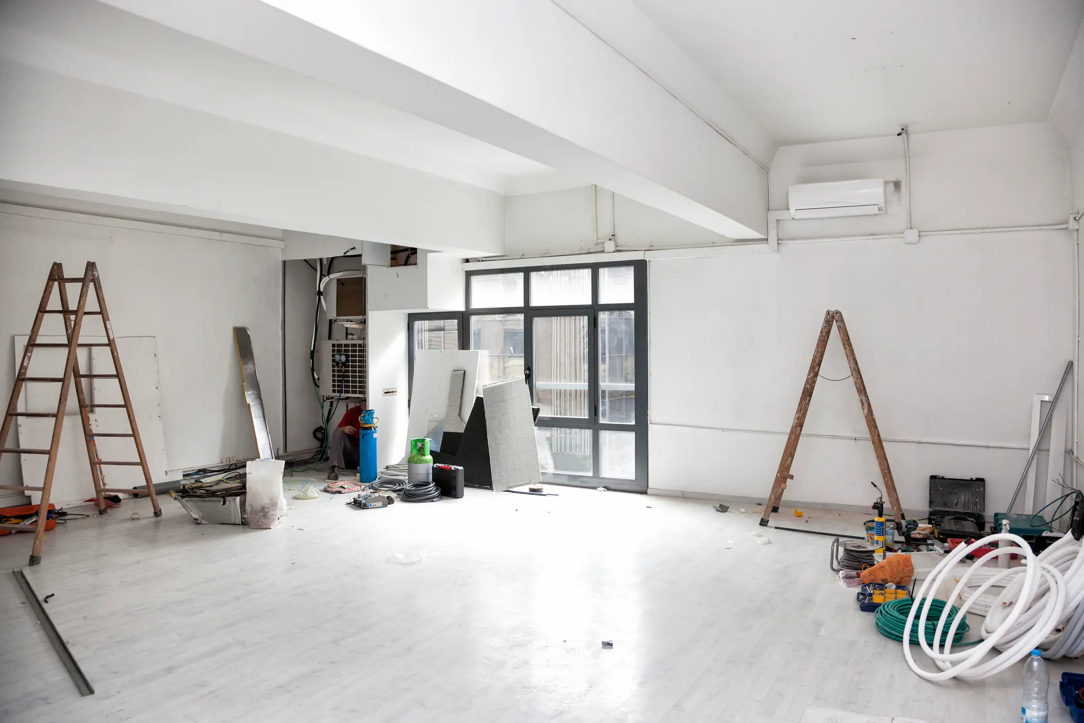 Room under renovation with ladders and tools.
